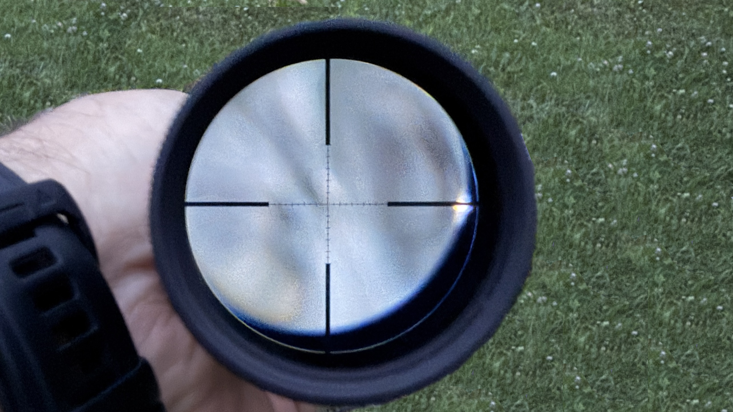 Pohled okulárem puškohledu na dělený kříž reticle používaný pro korekci v MOA nebo MRAD